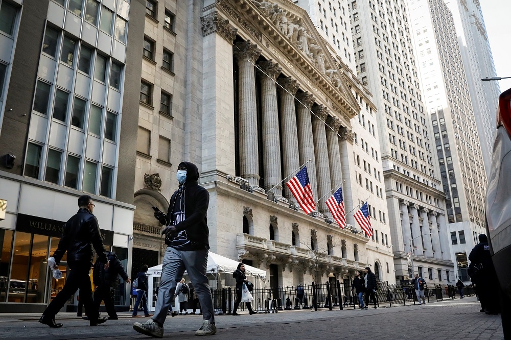 隨著武漢肺炎疫情升溫，紐約證卷交易所（NYSE）前經過的民眾戴起口罩。（湯森路透）