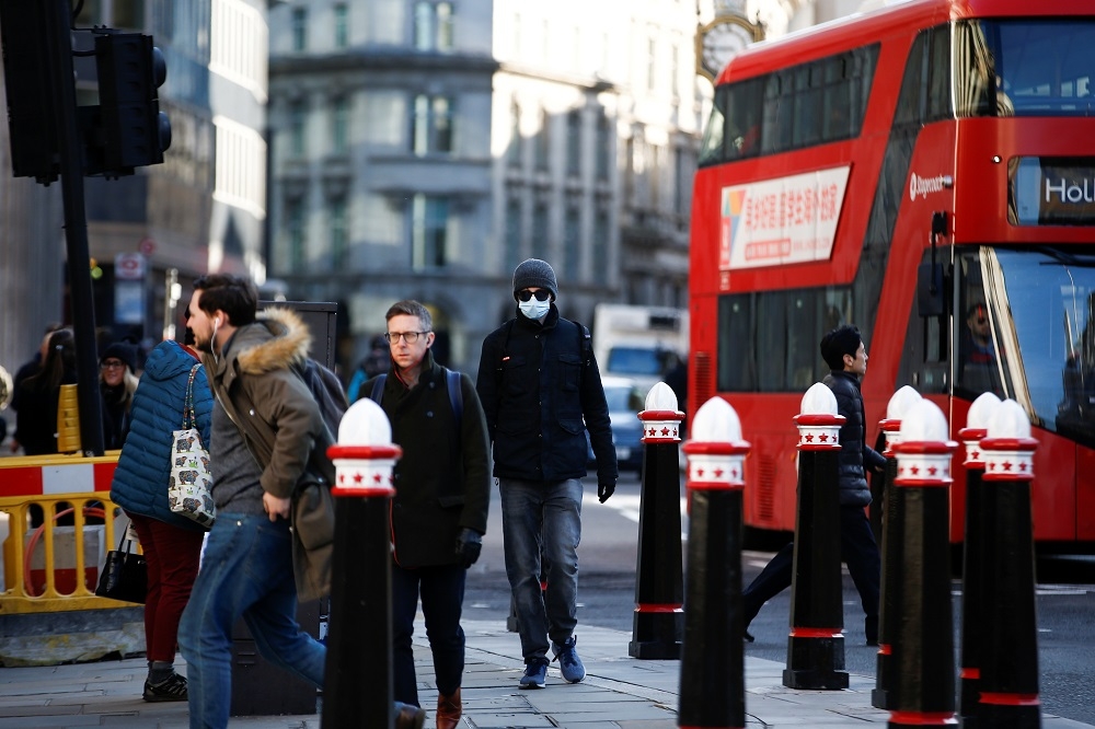 隨著疫情愈加嚴峻，倫敦街頭有民眾開始戴起口罩。（湯森路透）