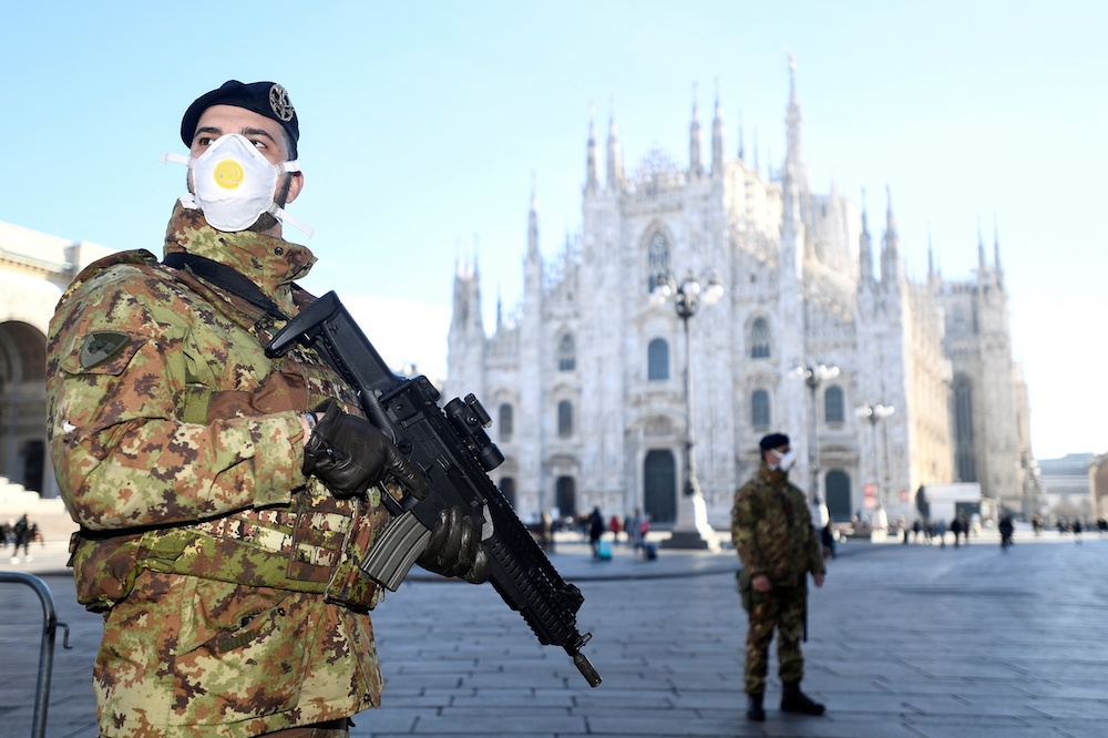 義大利米蘭主教座堂前的軍警也戴上口罩防疫。 （湯森路透）