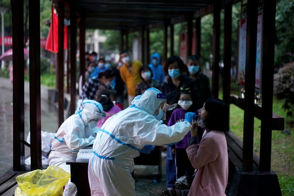中國湖北省武漢市社區14日進行新冠肺炎病毒篩檢。（湯森路透）