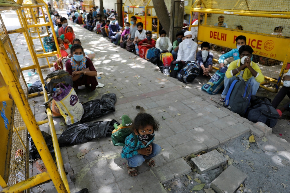 大批印度外地工人等待接駁車前往隔離中心安置。（湯森路透）
