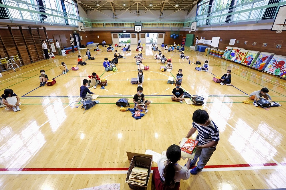 日本小學生在恢復上學後實施社交距離政策。（湯森路透）