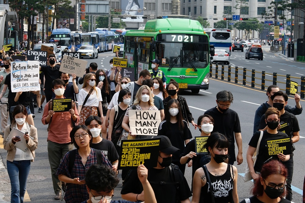 南韓疫情尚未完全獲得控制，民眾日前帶著口罩上街聲援非裔男子佛洛伊德。（湯森路透）
