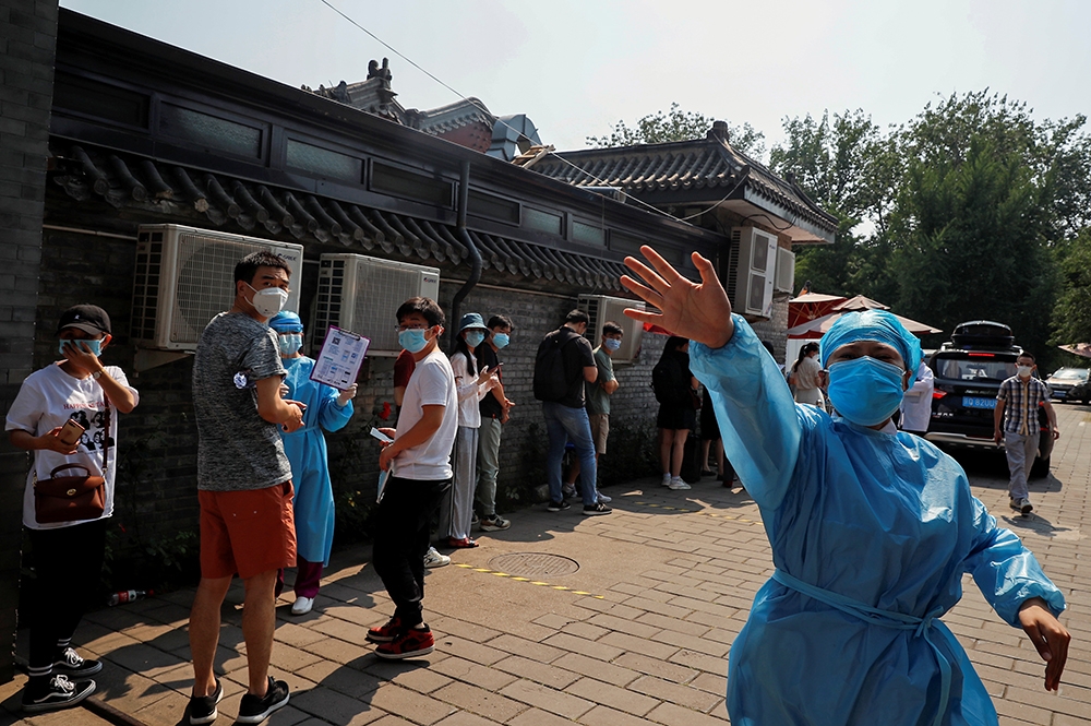 北京疫情再現，民眾排隊前往進行檢測。（湯森路透）