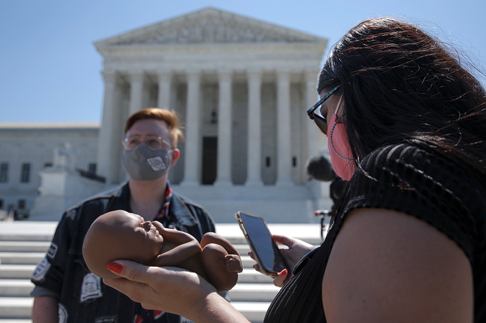 美國反墮胎人士在位於華盛頓的最高法院面前拿著胎兒雕塑。（湯森路透）