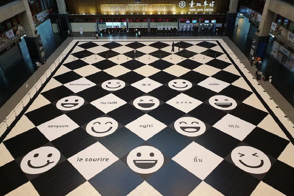 台北車站大廳以寫著微笑的10種語文和地貼換上新裝，大改之前欲禁止民眾席地而坐的決策髪夾灣，把空間還給人的自由活動。（圖片摘自台鐵管理局臉書）