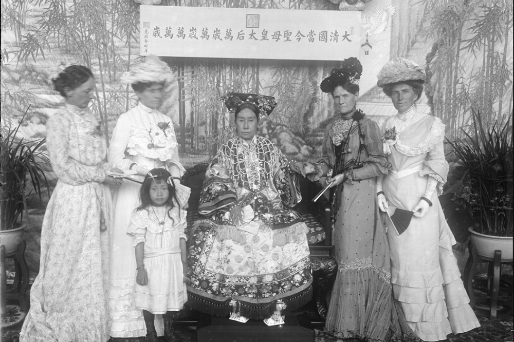 慈禧手握美國派駐北京的大使夫人莎拉．派克．康傑的手，其他三位來自美國使館的女士環繞在側，小女孩是攝影師勛齡的小女兒。（取自史密森尼博物院的賽克勒美術館）