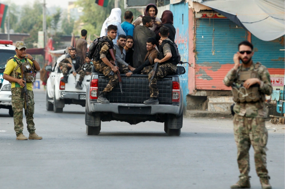 阿富汗軍警撤離交火區域的民眾。（湯森路透）