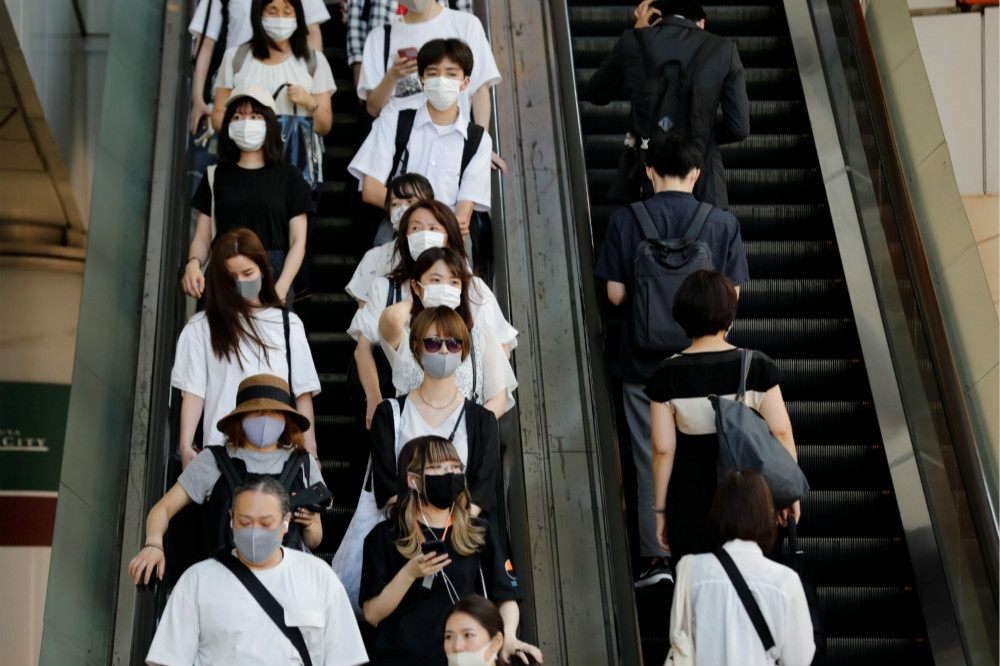 戴口罩搭乘地鐵的日本民眾。（湯森路透）