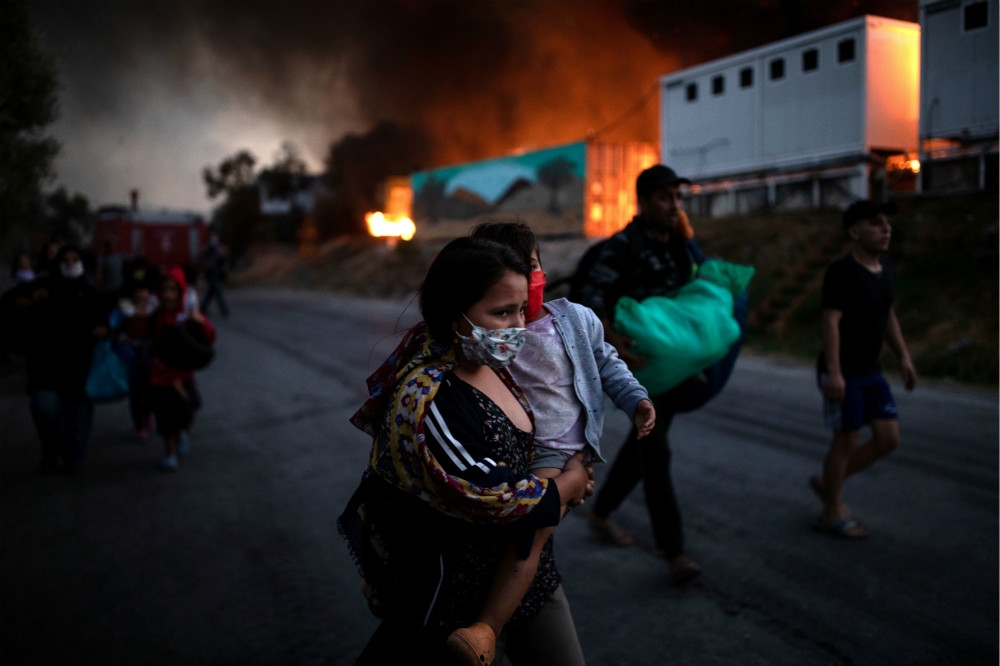 希臘列斯伏斯島的莫理亞難民營發生大火，眾多難民向外逃亡。（湯森路透）