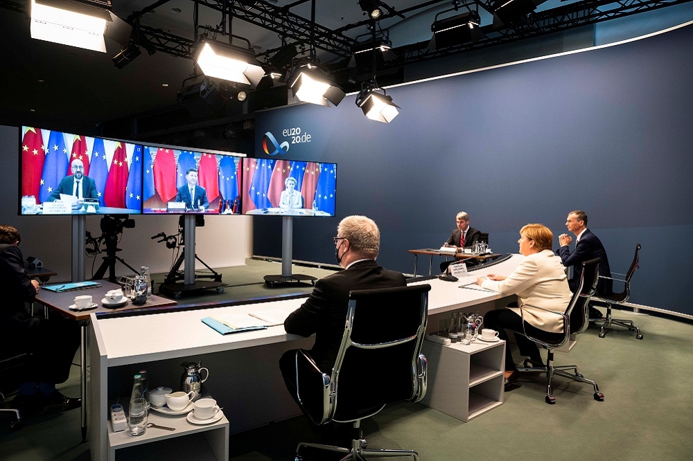 德國總理梅克爾與歐洲理事會主席米歇爾（電視畫面左）、中國國家主席習近平（中）、歐盟執委會主席范德賴恩（右）召開視訊會議。（湯森路透）