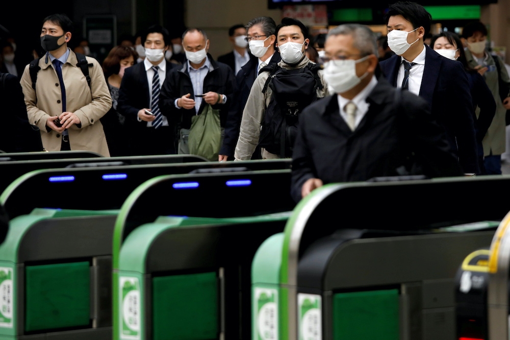 新冠肺炎在日本爆發後，民眾戴上口罩搭乘大眾運輸。（湯森路透）