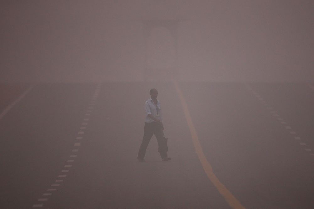 印度首都新德里的道路飄著黃色的霧霾。（湯森路透）