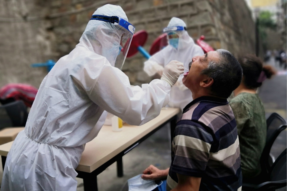醫護人員替新疆民眾進行普篩檢疫。（湯森路透）