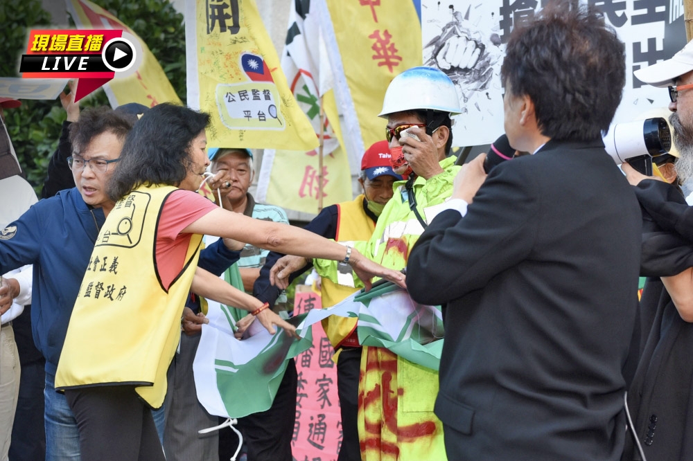 前新聞局長鍾琴在NCC總部前撕爛民進黨黨旗抗議。（張哲偉攝）