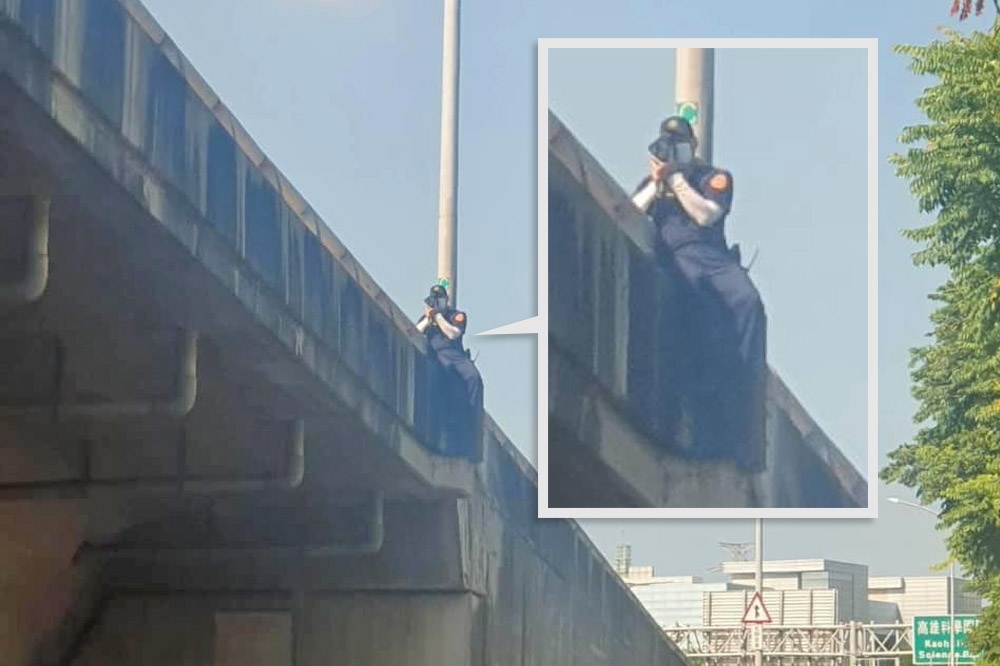 1名員警手拿測速槍，坐在橋墩上取締超速的照片在網路上流傳，被說是「要業績不要命」。（取自爆料公社公開版）