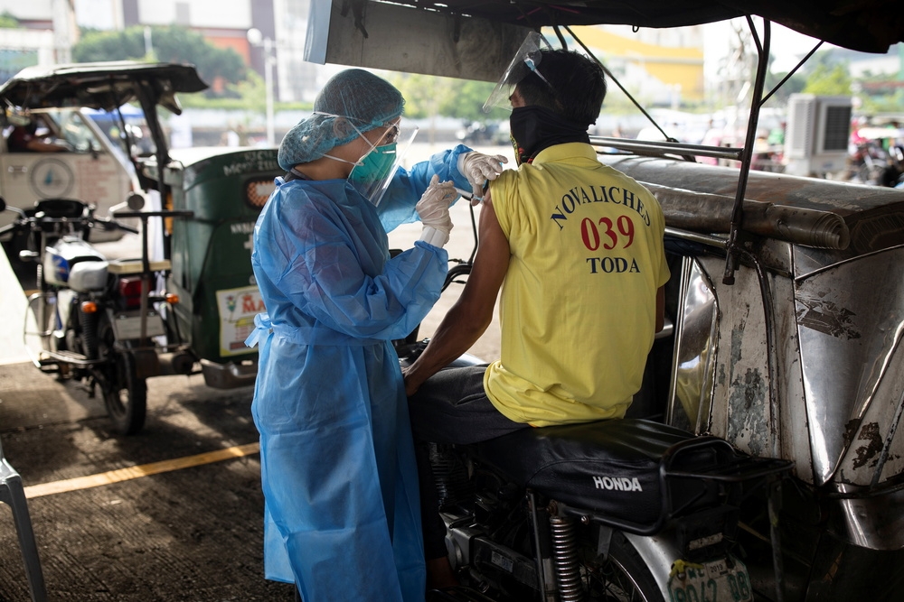 馬尼拉摩托車騎士接受疫苗接種。（湯森路透）