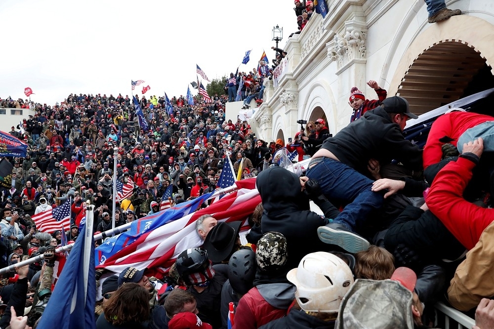 2021年1月6日，前美國總統川普的近千名支持者暴力闖入了國會大廈，短暫中止了大選最後認證程式，並引發與執法部門的居烈衝突。（湯森路透）