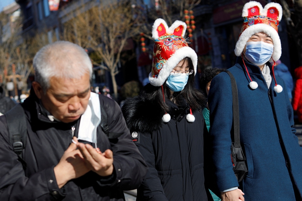 北京民眾戴口罩走春遊玩。（湯森路透）