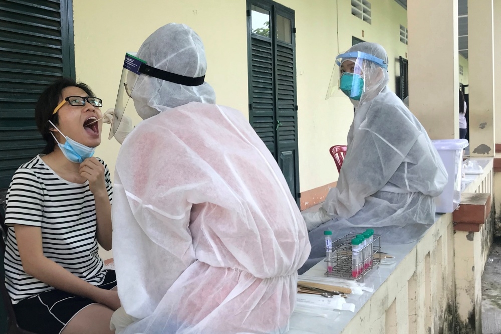 越南首都河內的衛生人員為民眾進行病毒核酸檢測。（湯森路透）