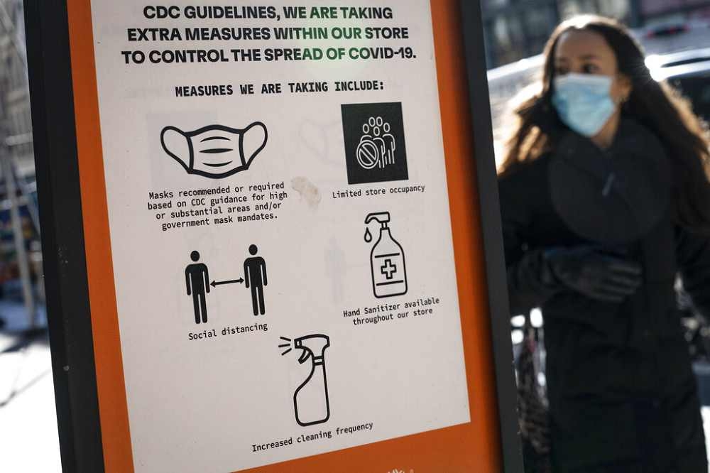 紐約市曼哈頓蘇活區（SoHo）的看板，提醒路人各項防疫措施。（美聯社）　