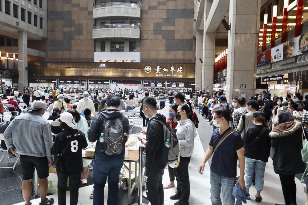 疫情再起，上千民眾天天塞爆台北車站的接種站，人群多到要發號碼牌。（攝影：王侑聖）