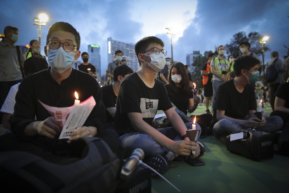香港學運人士羅冠聰（左）、黃之鋒（中）2020年出席維園悼念六四燭光晚會。（資料照片／美聯社）