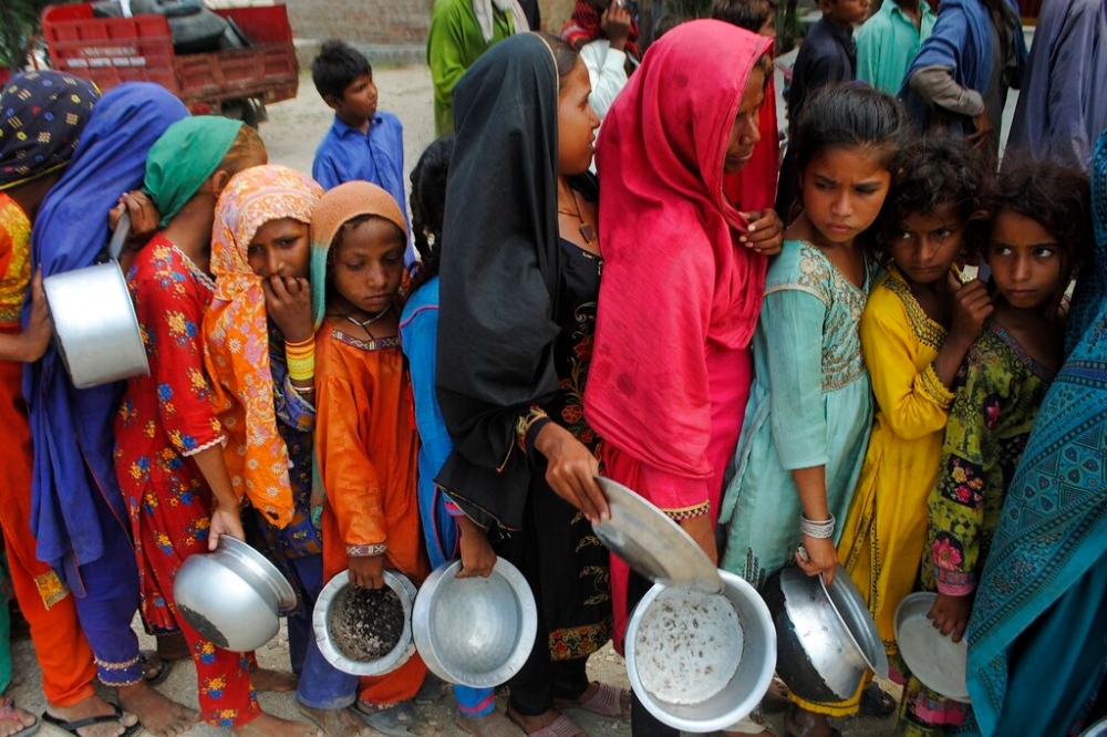 大洪水重創巴基斯坦信德省，民眾排隊領取慈善機構Saylani Welfare Trust提供糧食（美聯社）