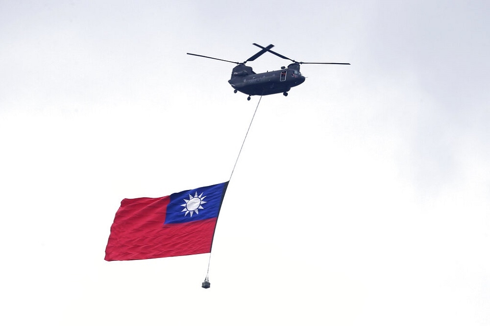 圖為台灣雙十國慶時，直升機載著中華民國國旗飛過總統府上方。（美聯社）