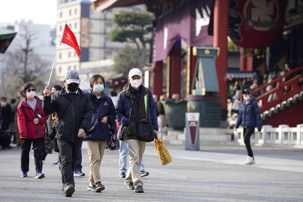 日本政府準備調降新冠肺炎的法定傳染病位階。圖為春節赴日旅遊的台灣旅行團。（美聯社）