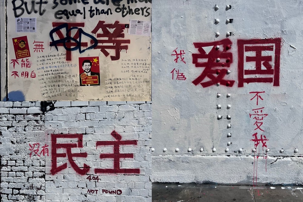 遭人塗白寫上「社會主義核心價值觀」的倫敦紅磚巷塗鴉牆，又有許多人再去塗改。（取自「李老師不是你老師」推特）