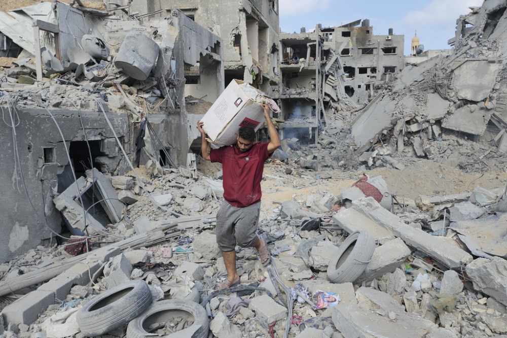 巴勒斯坦難民從瓦礫堆中搶救自己的財產。（美聯社）