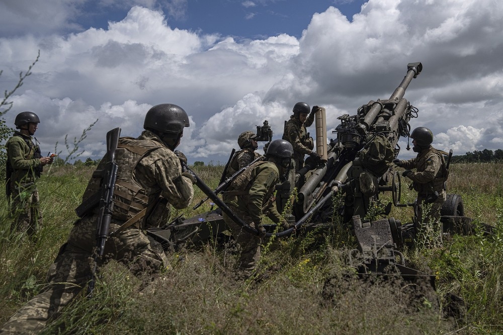 烏克蘭砲兵單位操作美援M777榴彈砲，向俄軍陣地進行攻擊。（美聯社）