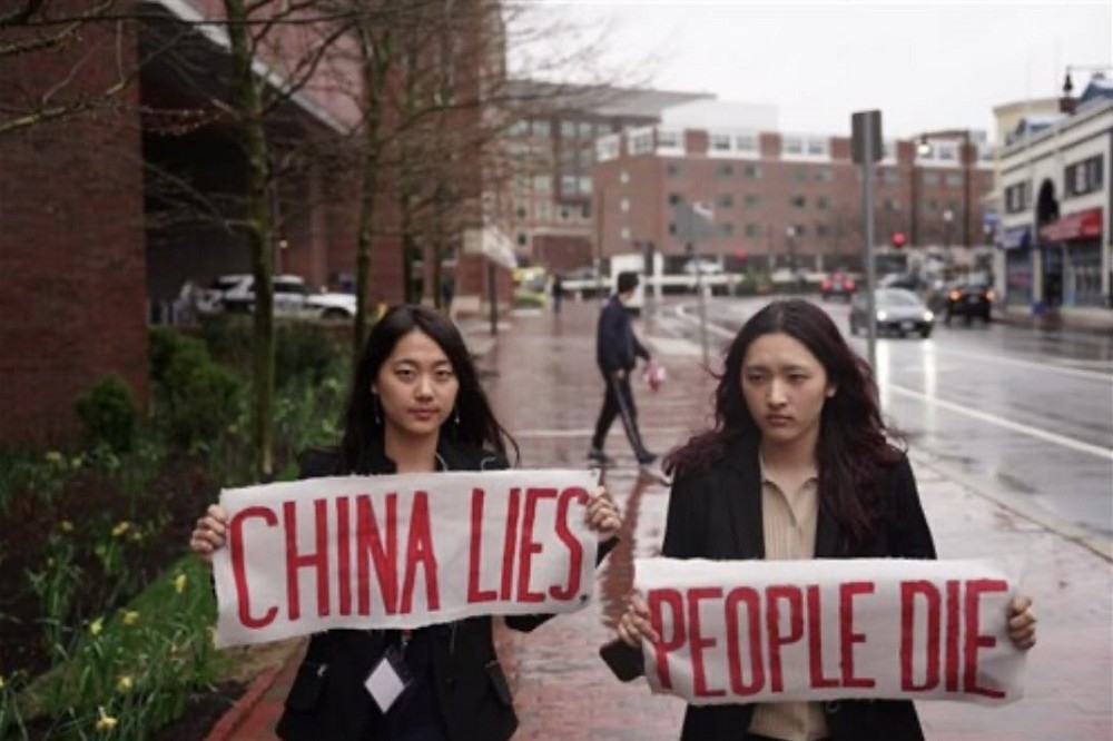 吳亭樺（左）及次仁央金（右）20日舉標語，抗議中國駐美大使謝鋒演說。（取自@22HomoPoliticus）