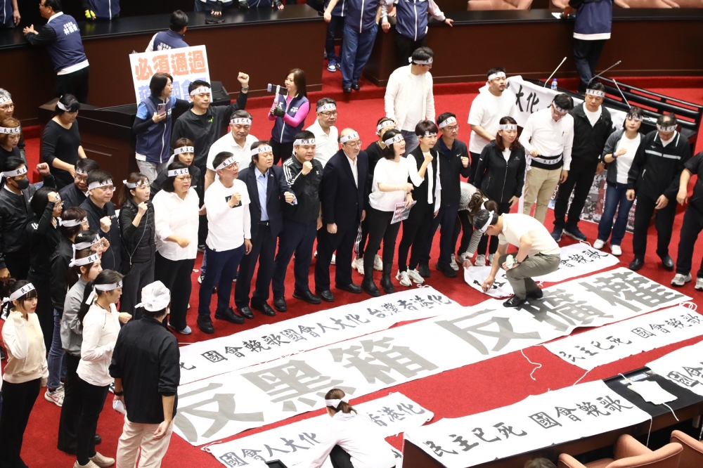 民進黨團今天在議場內提出「反黑箱、反擴權」的訴求，要求藍白陣營先協商。（王侑聖攝）
