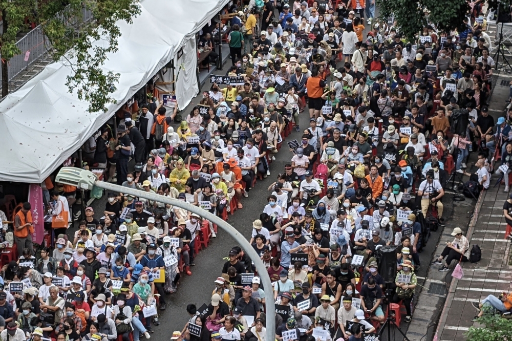 立院旁青島東路已經聚集了大批人潮，不少無法到場的民眾也化身「課金阿公、阿嬤」贊助他人到場。（王侑聖攝）