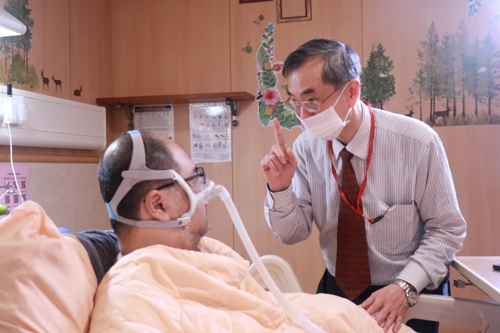 台大醫院醫師謝松蒼親自向漸凍症患者黃鼎承說明捐腦事宜。（取自台大醫院官網）