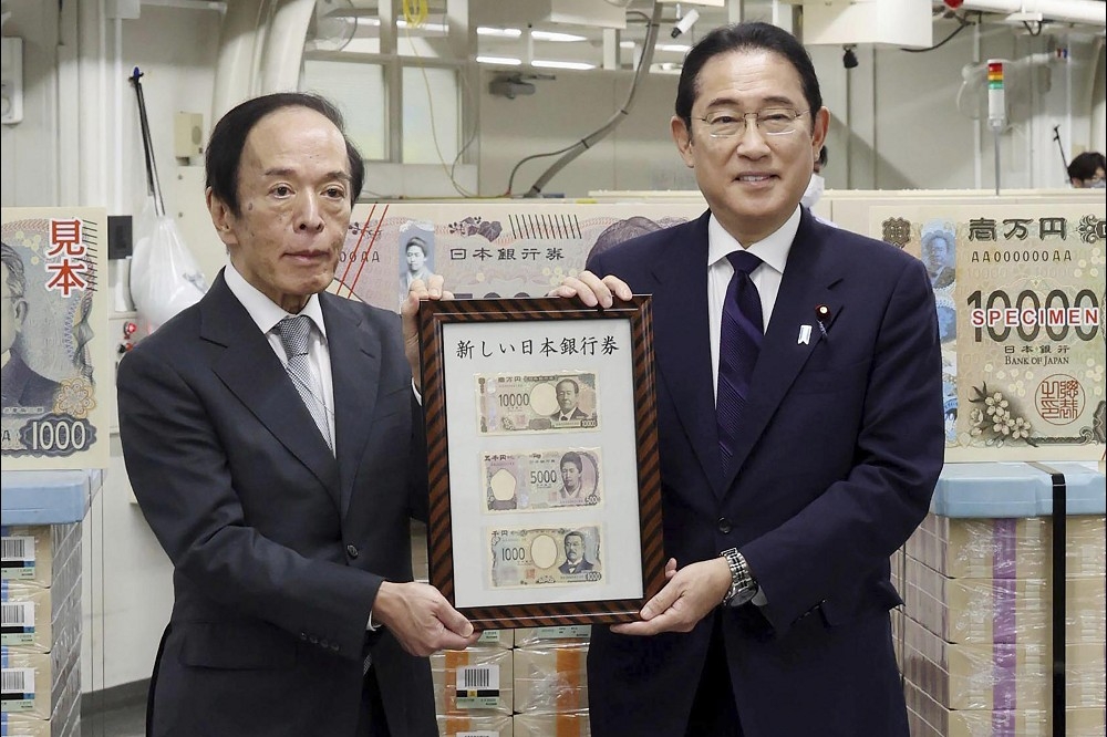 日本首相岸田文雄（右）與日銀總裁植田和男（左），今天在日銀總部宣布新鈔開始發行。（美聯社）