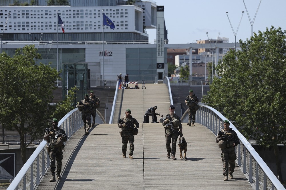 增派協助巴黎奧運開幕式的法軍士兵，在橫跨塞納河的人行橋上巡邏。（美聯社）