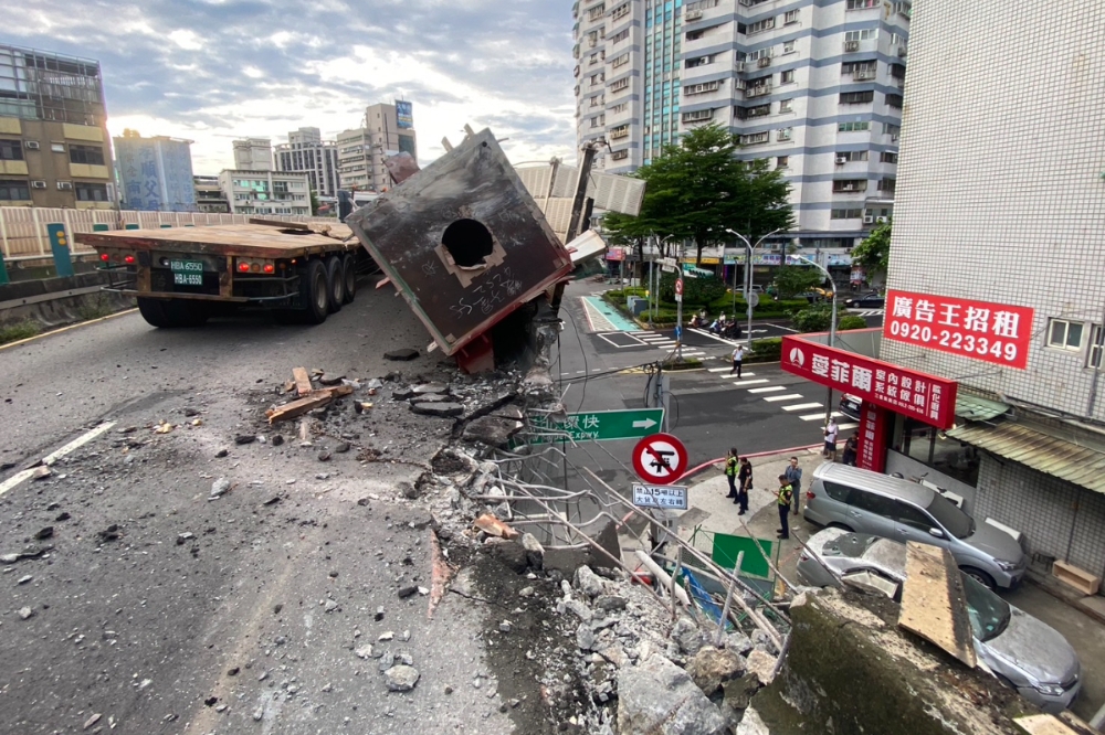 新北市三重區忠孝橋今天（20日）一早發生聯結車翻車事故，橋側護欄被撞破一個大洞，全線封閉處理。（新北市政府提供）